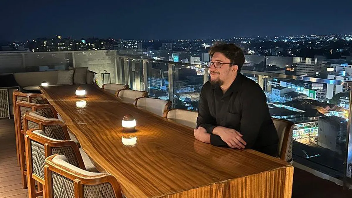 Djamel Bougouffa working at his desk with multiple monitors showing code